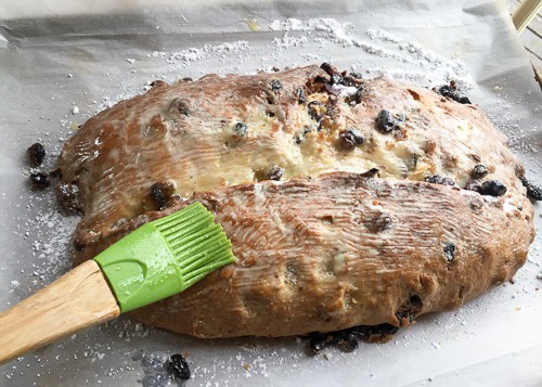 melted butter brushed over the first layer of butter and sugar of the Stollen bread