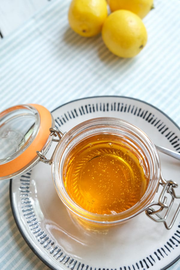 a jar of golden syrup on a plate with spoon