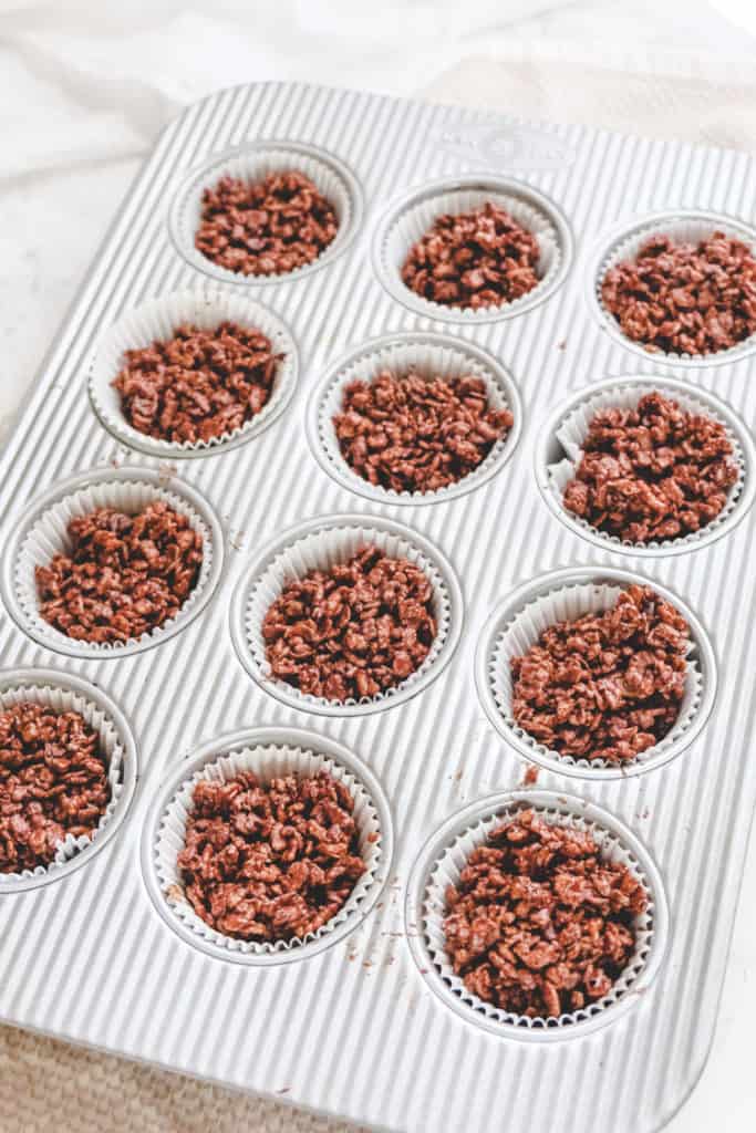 Chocolate Golden Syrup Rice Krispie Cakes on a muffin tin