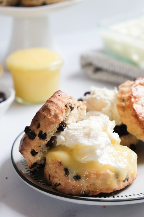British Currant Scones with cream and lemon curd on plate
