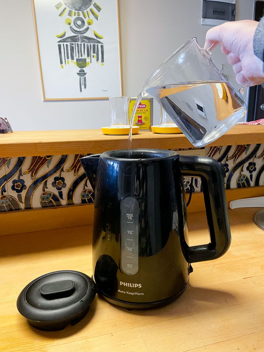 pour water into tea pot 